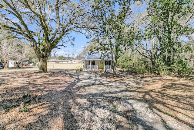 view of yard with a porch and fence