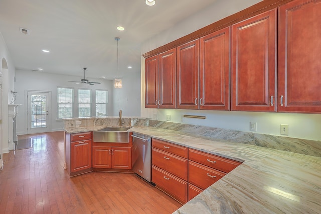 kitchen featuring kitchen peninsula, ceiling fan, decorative light fixtures, stainless steel dishwasher, and sink