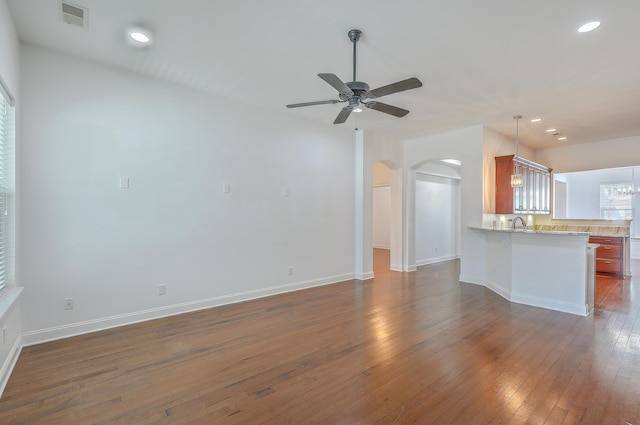 unfurnished living room featuring ceiling fan and dark hardwood / wood-style flooring