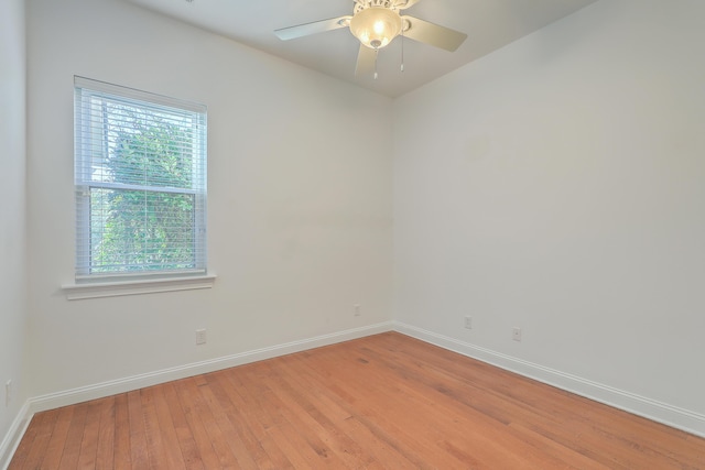 empty room with light wood-type flooring, ceiling fan, and a wealth of natural light