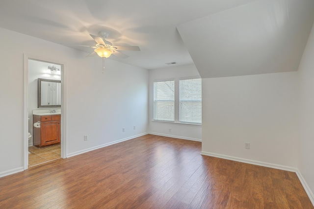 unfurnished bedroom featuring ceiling fan, ensuite bath, and light wood-type flooring