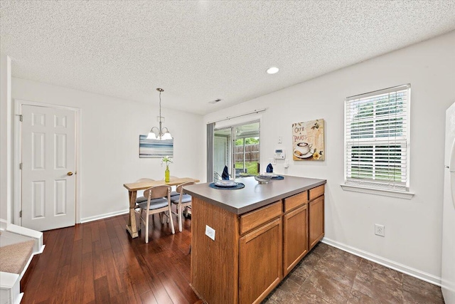 105 Brockman Way, Goose Creek, SC 29445 - kitchen with brown cabinets, a textured ceiling, decorative light fixtures, a peninsula, and a chandelier