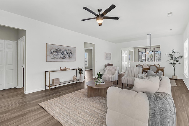 living room with ceiling fan and dark hardwood / wood-style flooring