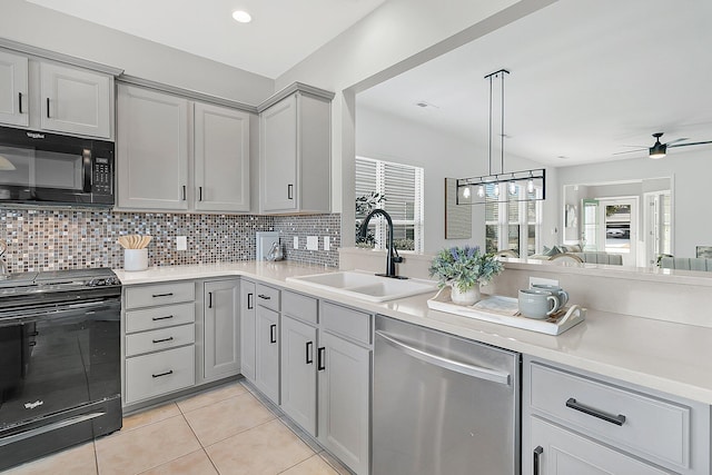 kitchen with sink, black appliances, gray cabinetry, and decorative backsplash