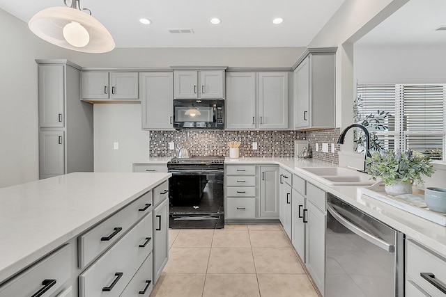 kitchen featuring light tile patterned floors, sink, black appliances, hanging light fixtures, and tasteful backsplash