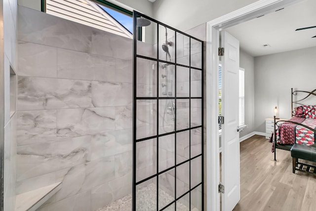 bathroom featuring tiled shower and wood-type flooring