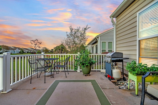 patio terrace at dusk featuring a grill