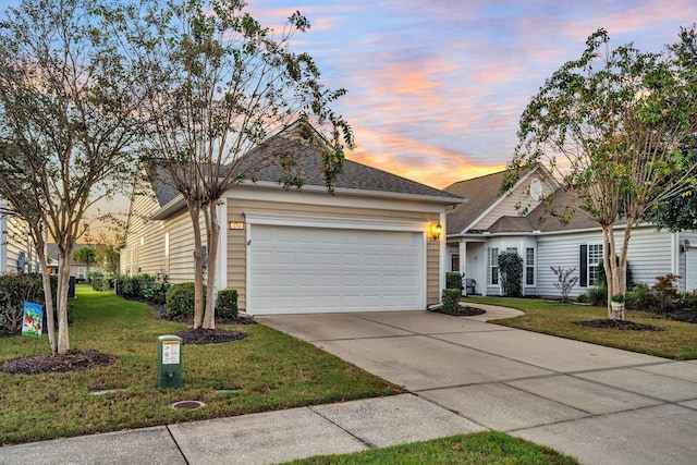 view of front of house featuring a garage and a lawn