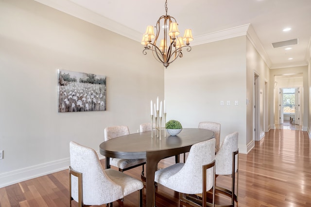 dining room with a notable chandelier, wood-type flooring, and crown molding