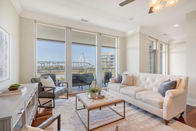 living room featuring crown molding, light hardwood / wood-style floors, and ceiling fan