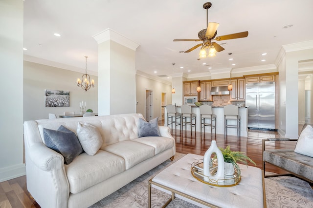 living room featuring ornamental molding, hardwood / wood-style flooring, and ceiling fan with notable chandelier