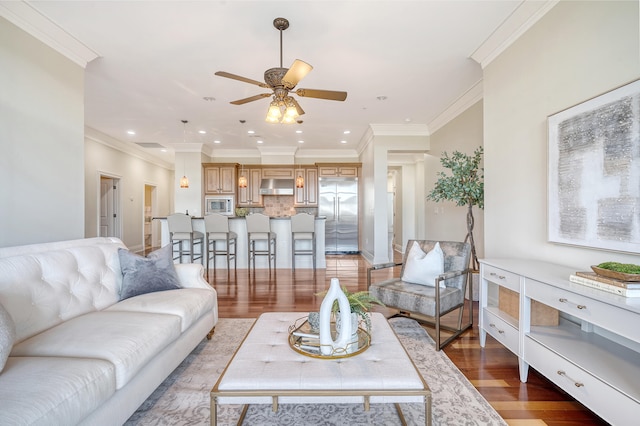 living room with ceiling fan, wood-type flooring, and ornamental molding