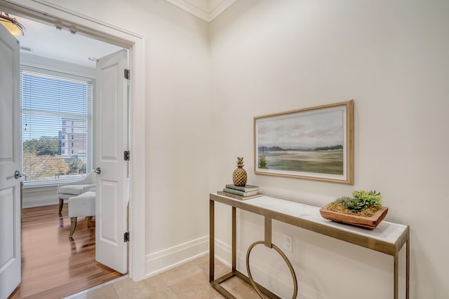 hallway featuring ornamental molding and light hardwood / wood-style flooring