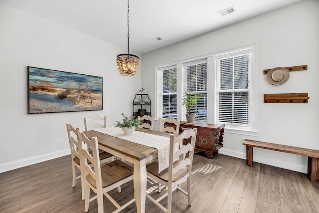 dining room featuring baseboards, a notable chandelier, and wood finished floors