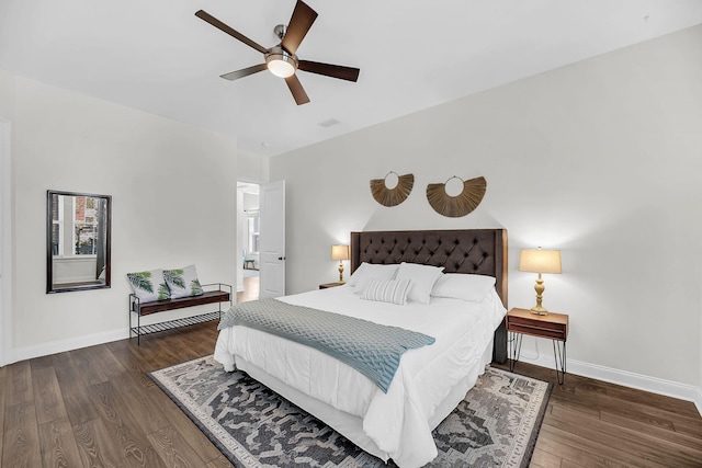 bedroom featuring a ceiling fan, ensuite bathroom, baseboards, and wood finished floors