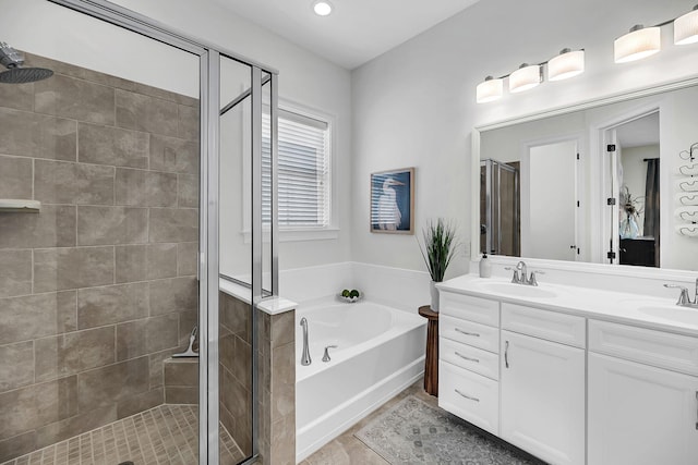bathroom with tile patterned flooring, a shower stall, a sink, double vanity, and a bath