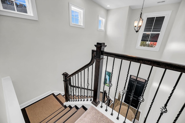 stairs featuring baseboards, visible vents, a chandelier, and recessed lighting