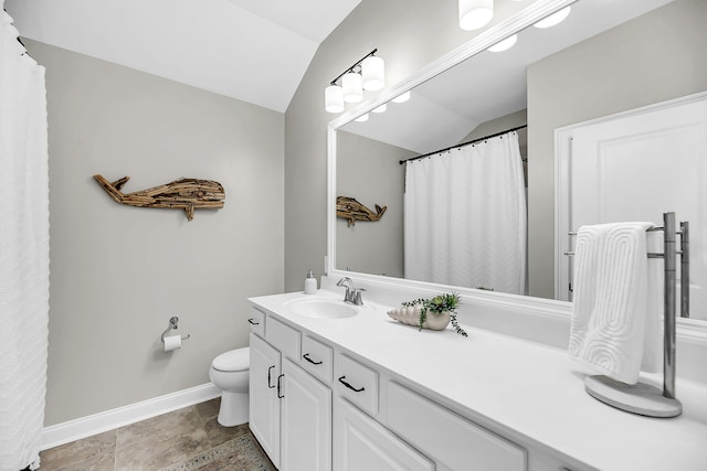 full bath with baseboards, lofted ceiling, toilet, and vanity