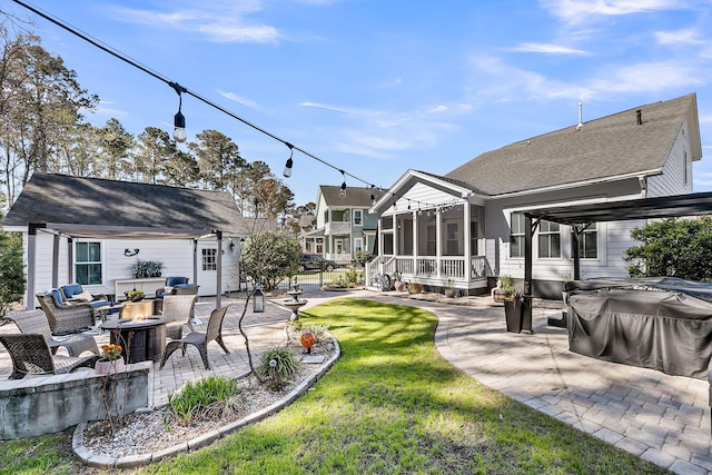 view of yard with a patio, an outbuilding, a sunroom, and an outdoor living space with a fire pit