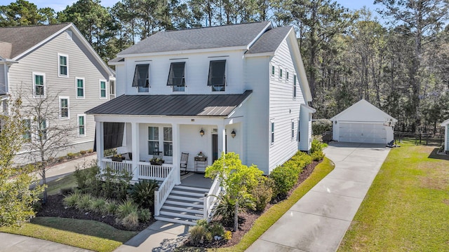 modern farmhouse style home with an outdoor structure, metal roof, a front yard, a porch, and a garage