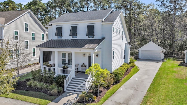 modern inspired farmhouse featuring a front yard, covered porch, an outbuilding, metal roof, and a garage