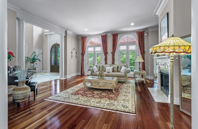 living area with crown molding, decorative columns, recessed lighting, wood finished floors, and baseboards