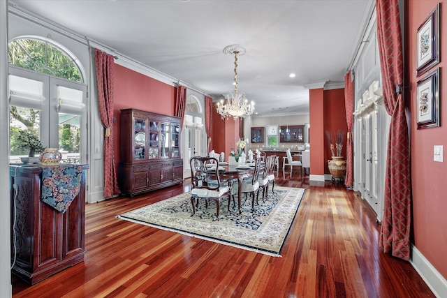 dining space featuring baseboards, an inviting chandelier, crown molding, and wood finished floors