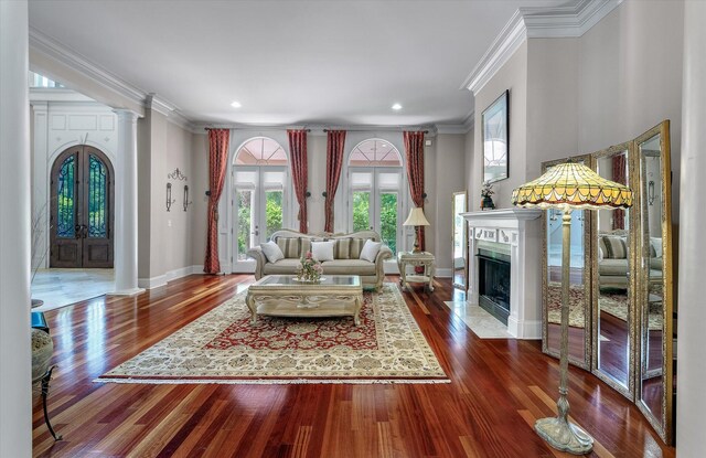 living room featuring crown molding, baseboards, a premium fireplace, and dark wood finished floors