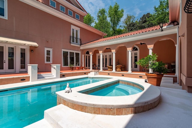 pool with a patio area, french doors, and an in ground hot tub