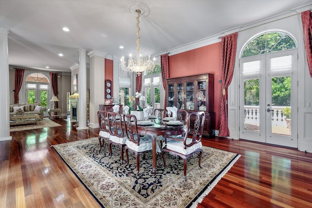 dining area featuring a chandelier, crown molding, ornate columns, recessed lighting, and wood finished floors