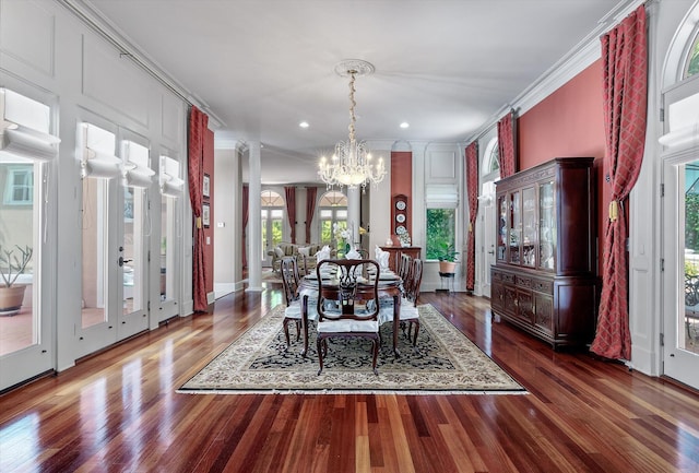 dining space with ornamental molding, recessed lighting, a notable chandelier, and wood finished floors
