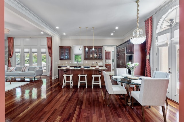 dining area with recessed lighting, dark wood-style flooring, an inviting chandelier, and ornamental molding