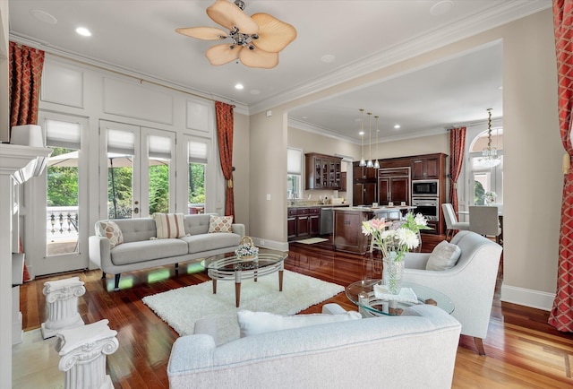 living room with a wealth of natural light, baseboards, and wood finished floors