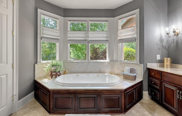 bathroom featuring a bath, baseboards, and a healthy amount of sunlight