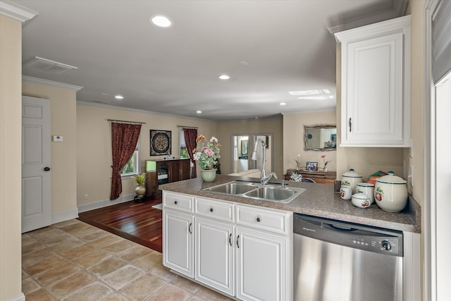 kitchen featuring a peninsula, crown molding, stainless steel dishwasher, and a sink