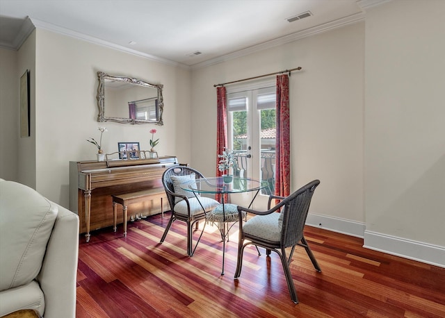 dining space with visible vents, baseboards, ornamental molding, and wood finished floors