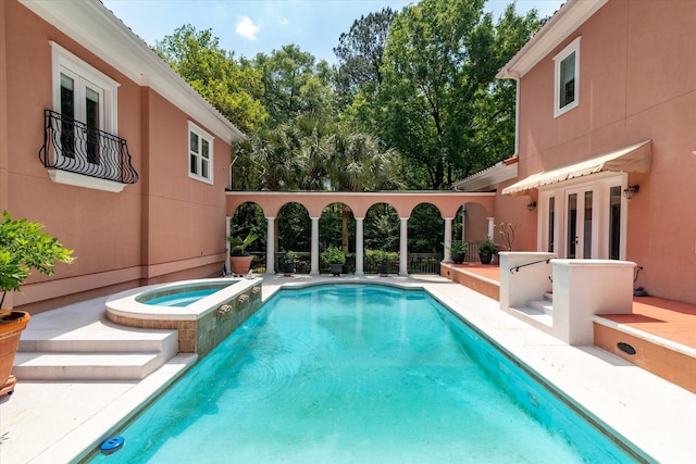 pool featuring a patio, an in ground hot tub, and french doors