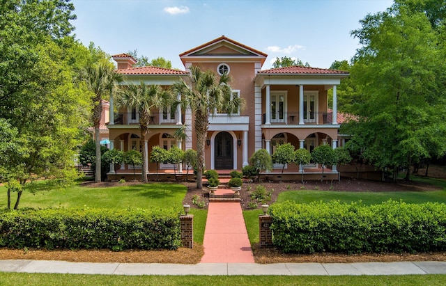 mediterranean / spanish home with a porch, a balcony, french doors, and a tile roof