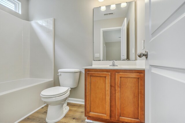 full bathroom featuring vanity, toilet, wood-type flooring, and shower / bath combination