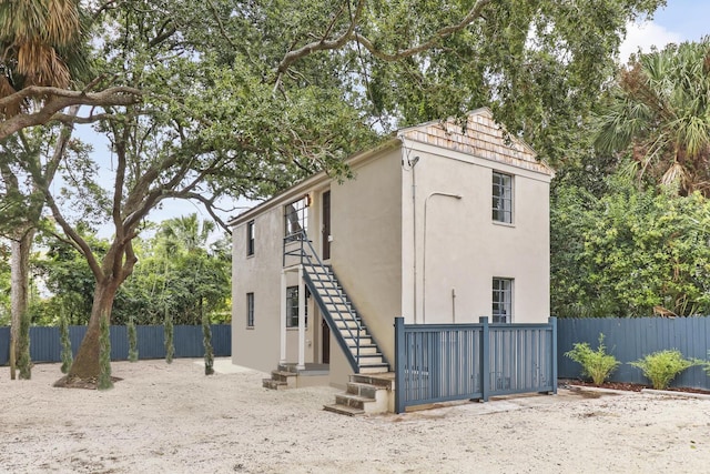 19 Smith St Unit D, Charleston, SC 29401 - view of side of home featuring stucco siding, fence, and stairs