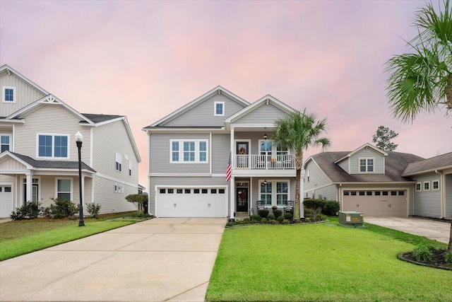 view of front of house with driveway, a yard, a balcony, and an attached garage