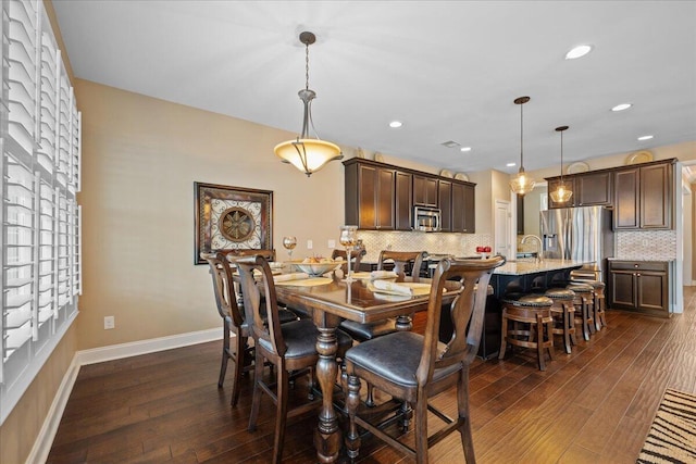 dining area featuring dark wood-type flooring, recessed lighting, and baseboards