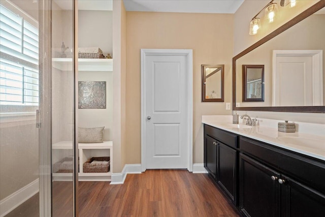 bathroom featuring vanity, baseboards, and wood finished floors