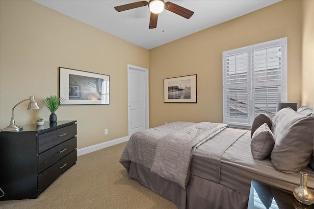 bedroom with light carpet, ceiling fan, and baseboards