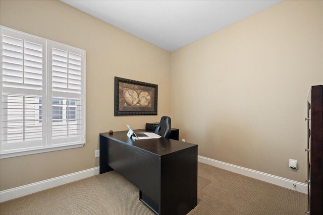 office space featuring baseboards and light colored carpet