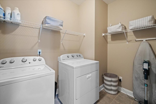 clothes washing area with laundry area, tile patterned flooring, baseboards, and independent washer and dryer