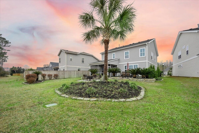 rear view of property with fence and a yard