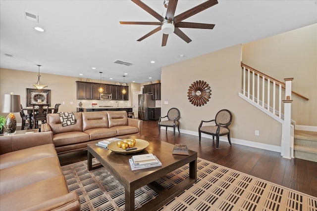 living area featuring dark wood-style flooring, recessed lighting, visible vents, baseboards, and stairs