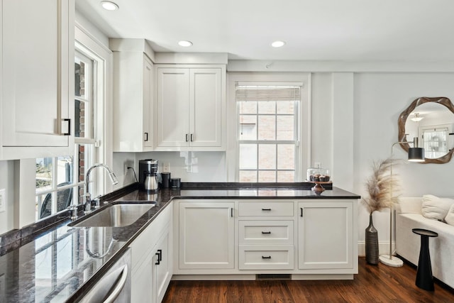 kitchen with a sink, dark stone countertops, dark wood-style floors, white cabinetry, and dishwasher