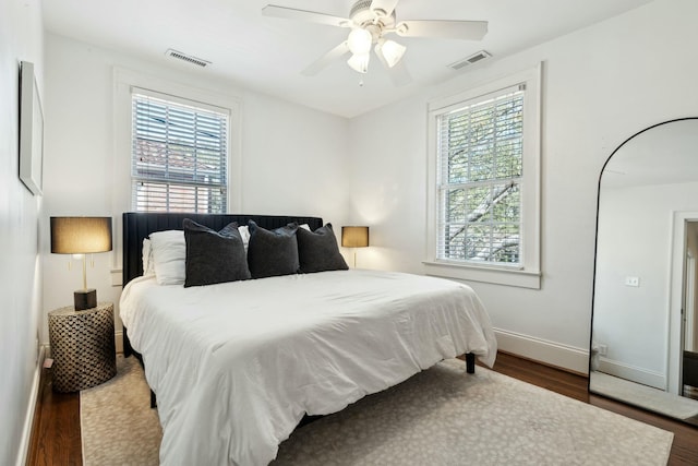 bedroom featuring multiple windows, wood finished floors, and visible vents